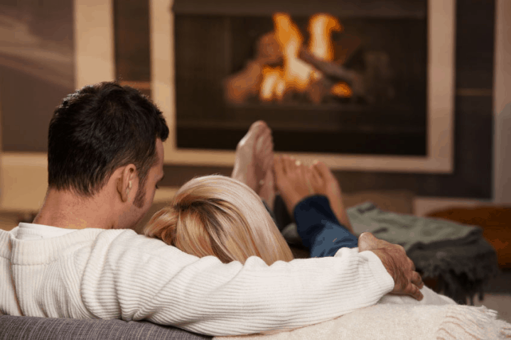 An introvert couple sitting in front of a fireplace